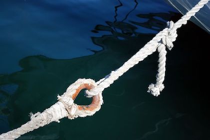 Two looped ropes attached to one another, over water. 