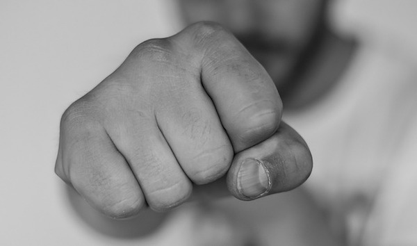 Close up black and white view of a man holding his fist outward. 