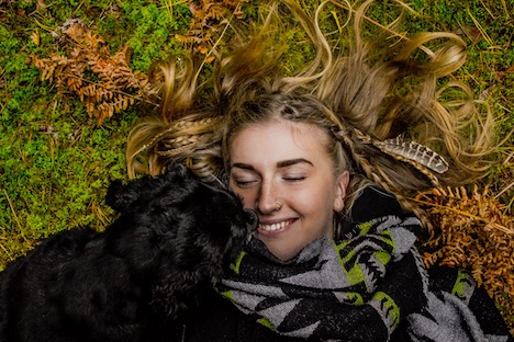 Overheard view of a woman smiling with her puppy. 