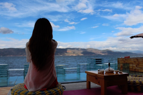 Rear view of a woman looking out into the water on a beach. 