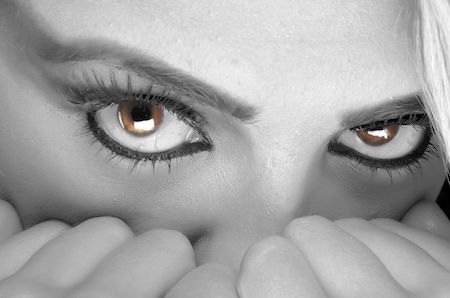 Black and white photo of a womans eyes, her eyes are brown and in color. 