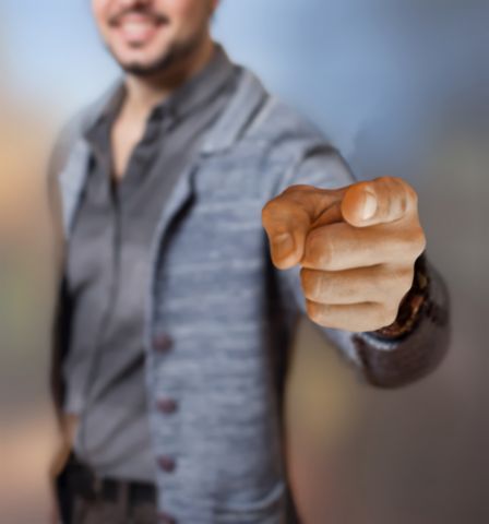 Man smiling and pointing his finger directly into the camera. 