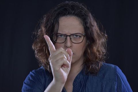 Close up portrait of a woman shaking her finger and waving NO. 